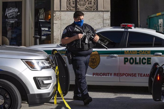 Un oficial de policía vigila las afueras de un centro comercial de EEUU después de un tiroteo.
