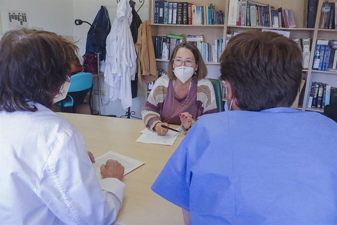 Profesionales sanitarios pasan consulta a una paciente, en foto de archivo