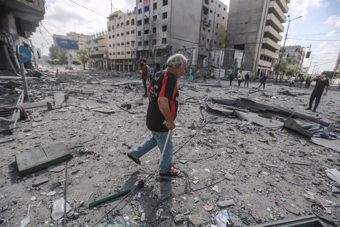 12 May 2021, Palestinian Territories, Gaza City: Palestinians inspect the severely damaged Al-Jawhara Tower area in Gaza City after it was hit by Israeli airstrikes amid the escalating flare-up of Israeli-Palestinian violence. The Health Ministry in the