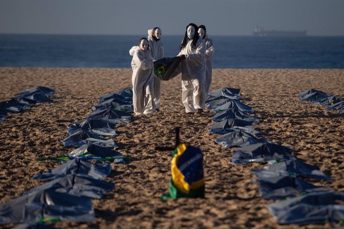 30 April 2021, Brazil, Rio De Janeiro: Members of the NGO "Rio de Paz" symbolically perform a funeral on Copacabana beach after the most populous country in Latin America passed the mark of 400,000 confirmed deaths related to Coronavirus (Covid-19). Pho