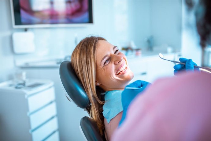 Mujer sonriendo en la consulta de un dentista.