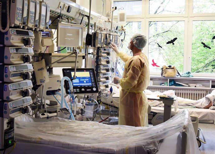 12 May 2021, Saxony-Anhalt, Halle: A specialist nurse for anaesthesia and intensive care, checks an infusion and syringe pump tower at a patient's bedside next to an empty bed in the interdisciplinary intensive care unit in the Coronavirus (Covid-19) ar