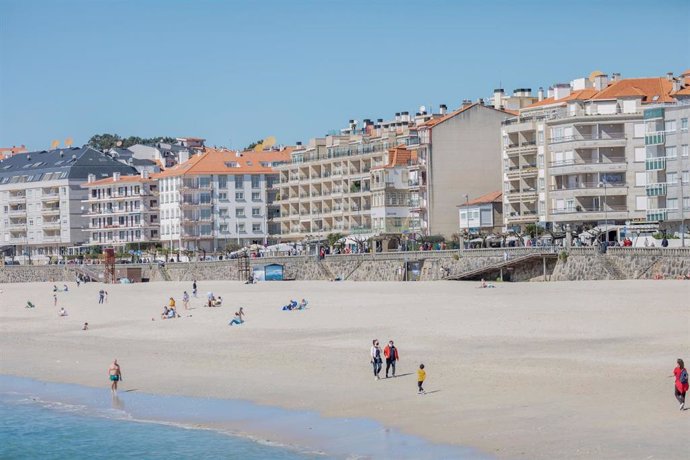 Archivo - Varias personas pasean por la playa de Sanxenxo, Pontevedra, Galicia (España), a 21 de marzo de 2021. El pasado miércoles el Ministerio de Sanidad y las Comunidades Autónomas acordaron una serie de medidas a aplicar durante el puente de San Jo