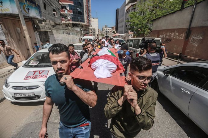 15 May 2021, Palestinian Territories, Gaza City: Palestinians carry the bodies of the Abu Hatab family during their funeral in Gaza City. Eight children and two women, all belonging to the Abu Hatab family, were killed in the three-storey building in Sh