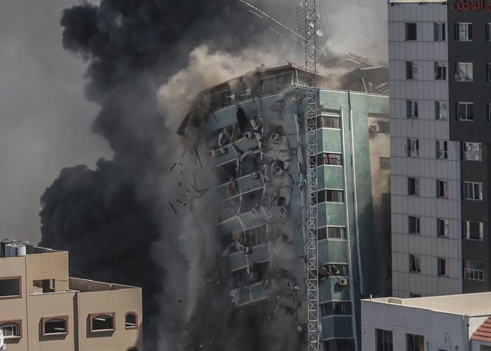 15 May 2021, Palestinian Territories, Gaza City: Al-Jalaa tower, which houses apartments and several media outlets, including The Associated Press and Al Jazeera, collapse after being hit by Israeli airstrikes, amid the escalating flare-up of Israeli-Pa