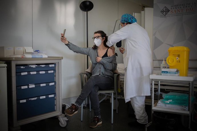 Archivo - Una enfermera vacuna a un profesional sanitario con la vacuna de Pfizer-BioNtech contra el COVID-19 en el Hospital de la Santa Creu i Sant Pau de Barcelona.