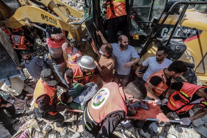 16 May 2021, Palestinian Territories, Gaza City: Palestinian paramedics dig up the body of a dead person found in the rubble of a collapsed house following an Israeli airstrike, amid the escalating flare-up of Israeli-Palestinian violence. Photo: Mohamm