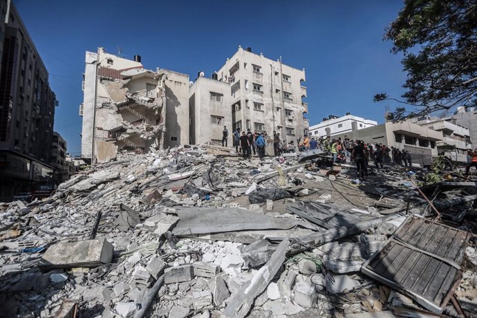 16 May 2021, Palestinian Territories, Gaza City: Residents and members of the Palestinian Civil Defence gather at a site hit by Israeli airstrike, amid the escalating flare-up of Israeli-Palestinian violence. Photo: Mohammed Talatene/dpa