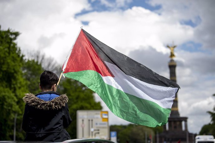 16 May 2021, Berlin: A boy holds a Palestinian flag at the big star during a motorcade to show solidarity with Palestinians amid the escalating flare-up of Israeli-Palestinian violence. Photo: Paul Zinken, Fabian Sommer/dpa