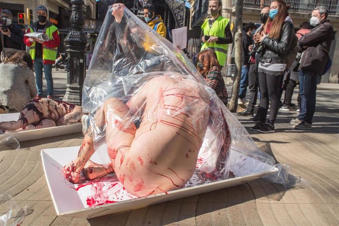 Archivo - 20 March 2021, Spain, Barcelona: Activists from the animal rights organization "AnimaNaturalis" lying in giant meat packages during a protest at La Boqueria market against meat consumption and to mark International Day Without Meat. Photo: Thi