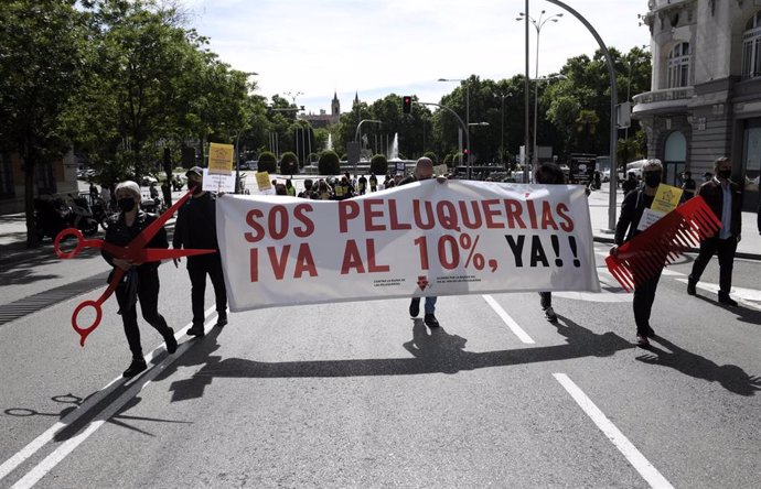 Grupos de personas se manifiestan con una pancarta donde se puede leer "SOS PELUQUERÍAS IVA AL 10% YA!!" en una manifestación organizada desde el Paseo del Prado hasta el Congreso de los Diputados, a 17 de mayo de 2021, en Madrid, (España).  