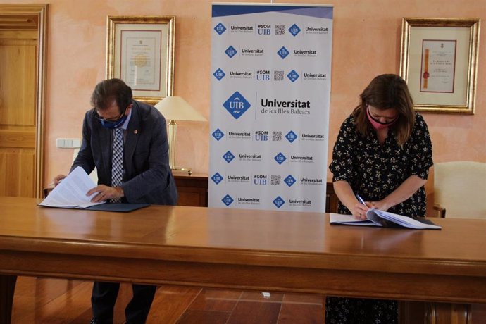 El rector de la UIB, Lloren Huguet, y la consellera de Presidencia, Función Pública e Igualdad, Mercedes Garrido, firmando el convenio.