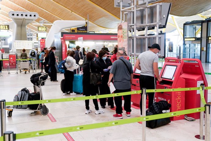 Varias personas en las máquinas de la T4 del aeropuerto Adolfo Suárez, Madrid-Barajas durante el primer día laboral tras el estado de alarma, a 10 de mayo de 2021, en Madrid (España). 