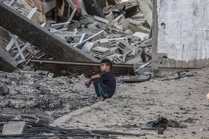 Un xiquet palestí assegut sobre les runes d'uns edificis afonats pels atacs aeris de les forces israelianes.