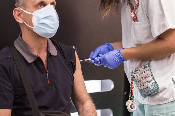 Una sanitaria administra la primera dosis de la vacuna de Pfizer a un hombre, en el Hospital Universitario de Getafe, a 17 de mayo, en Getafe, Madrid (España). La Comunidad de Madrid ha comenzado hoy a vacunar a personas entre 50 y 55 años en los hospit