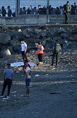 Personas migrantes en la playa del Tarajal, a 17 de mayo de 2021, en Ceuta (España). España ha movilizado al Ejército en la ciudad tras la entrada de más de 5.000 marroquíes en 24 horas.