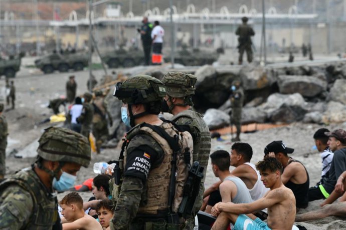 Varios militares del ejército español vigilan durante las devoluciones en caliente que están efectuando a los migrantes que han entrado en Ceuta procedente de Marruecos, a 18 de mayo de 2021, en Ceuta, (España). Al menos 2.700 personas han sido devuelta