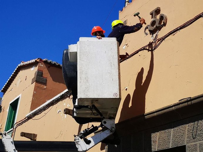 Un operario destruye a martillazos un símbolo relacionado con el franquismo, un 'vítor', junto a otro rótulo en presunto "cumplimiento de la Ley de Memoria Histórica"