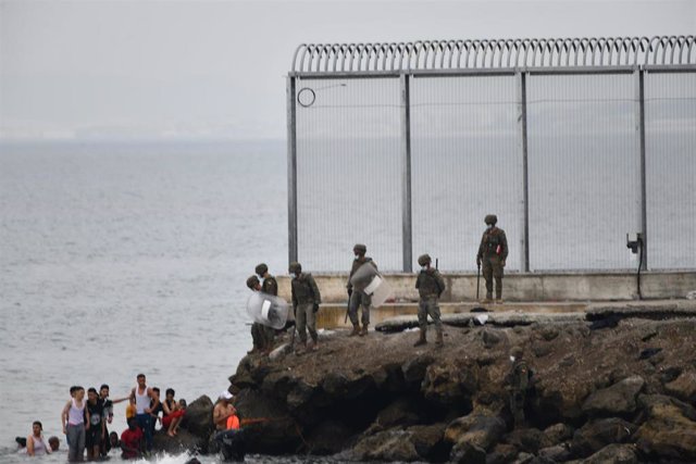 Militares del ejército español vigilan durante las devoluciones en caliente que están efectuando a los migrantes que han entrado en Ceuta procedente de Marruecos, a 18 de mayo de 2021, en Ceuta, (España)