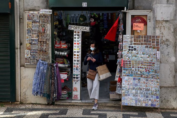 Una mujer sale de una tienda de recuerdos en Lisboa, Portugal