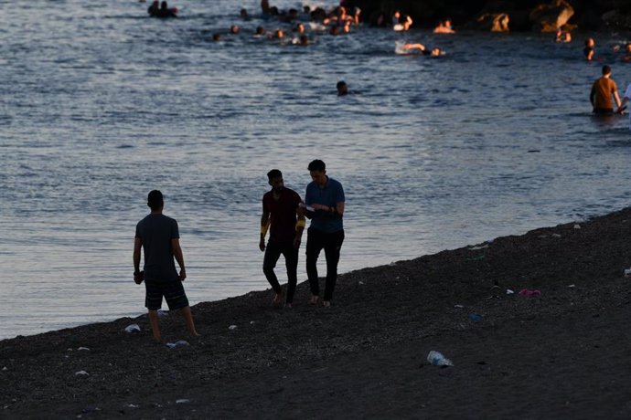 Un grupo de personas migrantes camina por la playa del Tarajal, en Ceuta.