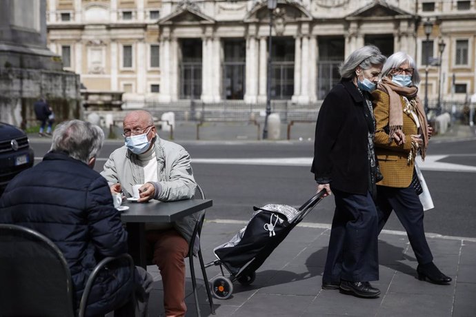 26 April 2021, Italy, Rome: People sit at the outdoor area of a coffee bar in Santa Maria Maggiore piazza on the first day of reopening after the easing of the coronavirus restriction. Restaurants and bars are allowed to open their outdoor seating areas