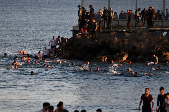 Personas migrantes en la playa del Tarajal, a 17 de mayo de 2021, en Ceuta (España). España ha movilizado al Ejército en la ciudad tras la entrada de más de 5.000 marroquíes en 24 horas.