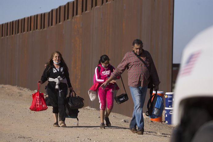 13 May 2021, US, Yuma: Migrants from Columbia turn themselves over to authorities after crossing the border by the wall separating the United States and Mexico. Photo: Ringo Chiu/ZUMA Wire/dpa