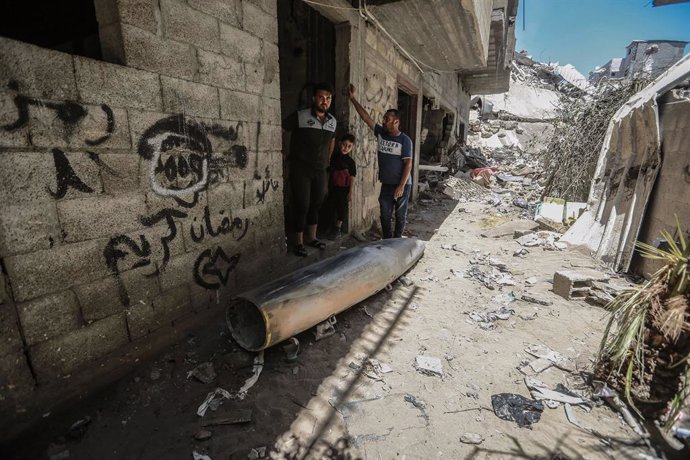 Palestinos junto a una bomba sin estallar lanzada por Israel contra la Franja de Gaza