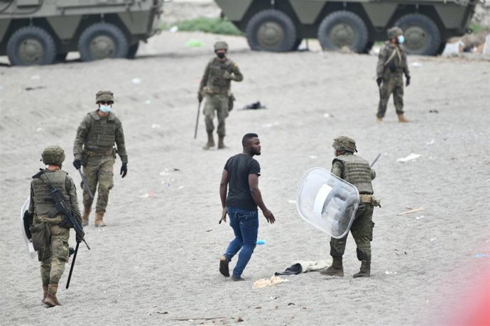 Militares del ejército español efectúan una devolución en caliente a uno de los migrantes que han entrado en Ceuta procedente de Marruecos.