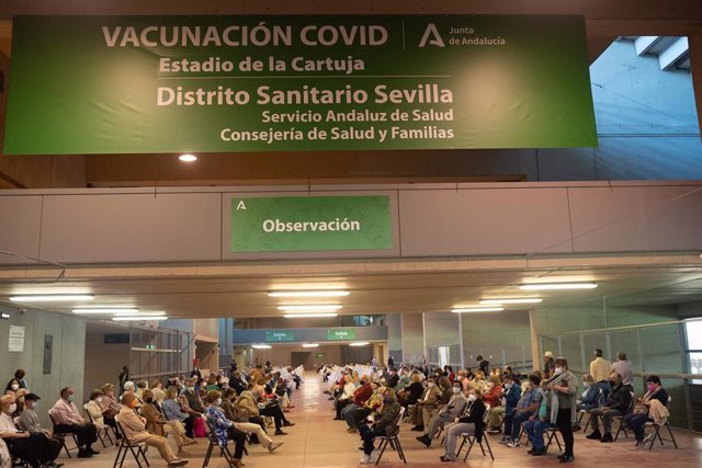 Varias personas esperan en el área de observación después de que les hayan administrada  la vacuna contra el Covid-19, a 28 de abril de 2021, en el Estadio de la Cartuja, en Sevilla, (España)