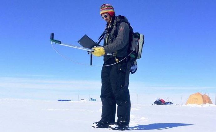 El investigador Gabriel Lewis mide la reflectividad en la capa de hielo de Groenlandia durante una expedición de investigación de 2016.