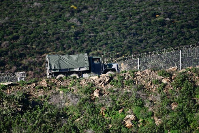 Archivo - Un camión del ejército marroquí patrulla frente al tramo del vallado perimetral que separa España de Marruecos, en Ceuta