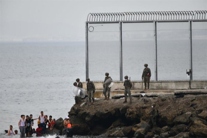Militares del ejército español vigilan durante las devoluciones en caliente que están efectuando a los migrantes que han entrado en Ceuta procedente de Marruecos, a 18 de mayo de 2021, en Ceuta, (España). 