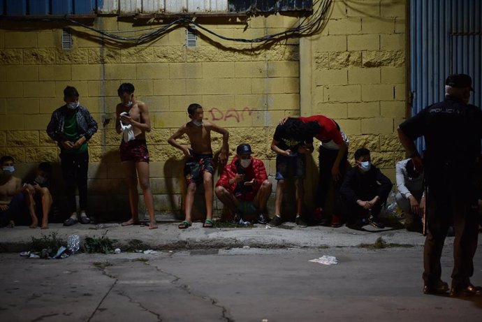 Migrantes descansan tras su llegada a la playa del Tarajal, este pasado día 17 