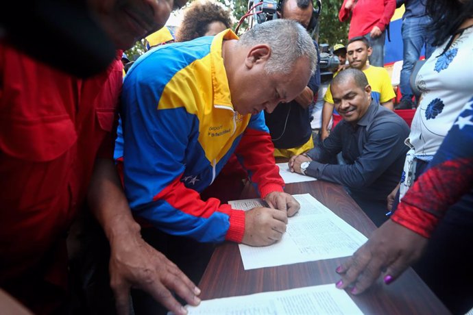 Archivo - 05 September 2019, Venezuela, Caracas: Diosdado Cabello, President of the Constituent Assembly, signs a document against the recent US sanctions against the incumbent Venezuelan government as part of a campaign under the motto "No more Trump".
