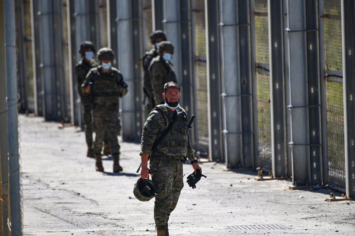 Varios militares vigilan desde la valla que separa Ceuta de Marruecos la llegada de migrantes, a 19 de mayo de 2021, en Ceuta, (España). 