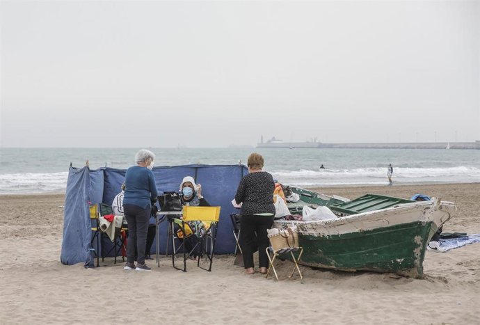 Archivo - Un grupo de varias personas con mascarilla en la playa la Malvarrosa, en Valencia en imagen de archivo
