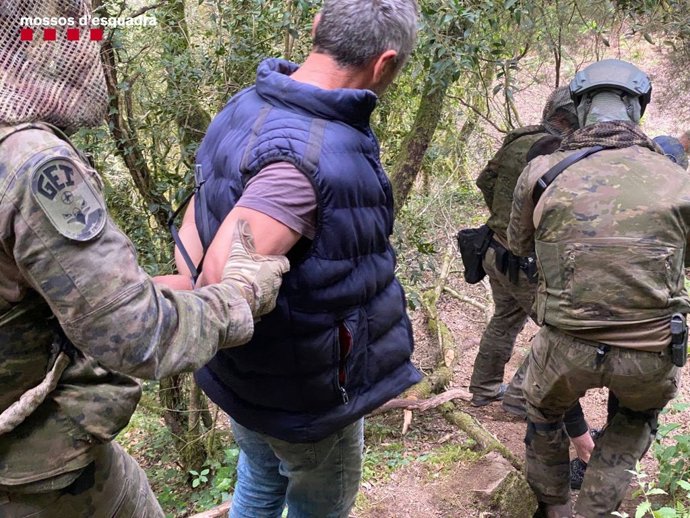 Imagen de un detenido con los agentes del Grupo Especial de Intervención (GEI)