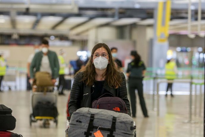 Archivo - Una joven protegida con mascarilla camina por el Aeropuerto de Madrid-Barajas Adolfo Suárez el día en el que se estrena el triple control sanitario de seguridad contra el Covid-19 que consiste en especificar si se ha pasado la enfermedad y en 