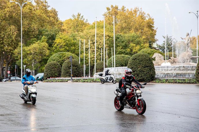 Archivo - Dos motoristas circulan con lluvia en la rotonda de la Fuente de Neptuno durante el peor temporal del otoño del 2019 en España en el que se verán afectadas 37 provincias avisadas por viento, nieve, oleaje o lluvia, en Madrid (España) a 14 de n