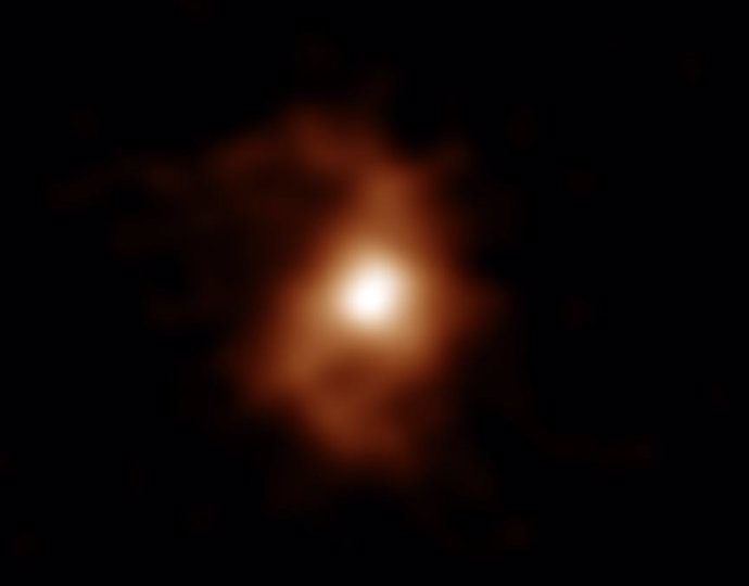 Imagen de ALMA de la galaxia BRI 1335-0417 hace 12.400 millones de años. ALMA detectó emisiones de iones de carbono en la galaxia. Los brazos espirales son visibles a ambos lados del área compacta y brillante en el centro de la galaxia.