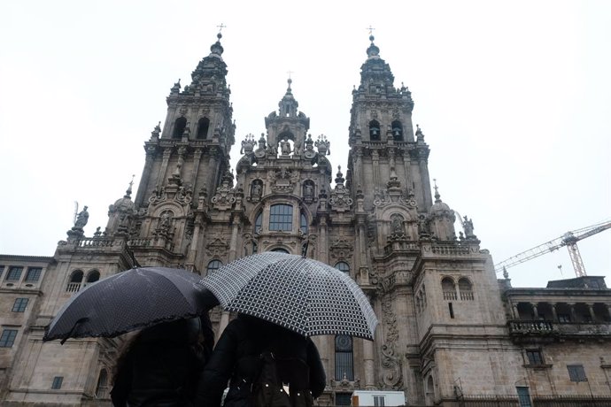 Una pareja observa la catedral de Santiago sin andamios después de varios años de obras, en Santiago de Compostela, A Coruña, Galicia (España)