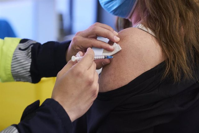 Un sanitario vacuna a una mujer con la dosis de Pfizer.