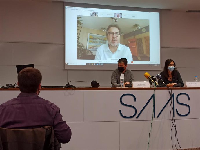 Marc Pons de Actua Innovació y la doctora Cristina Royo, con el doctor Antoni Plasncia en la pantalla, en rueda de prensa.