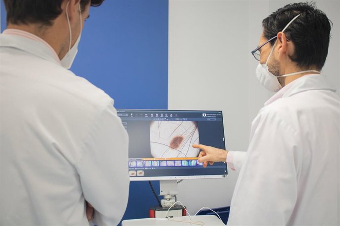 Profesionales sanitarios observan la imagen de una melanoma cutáneo