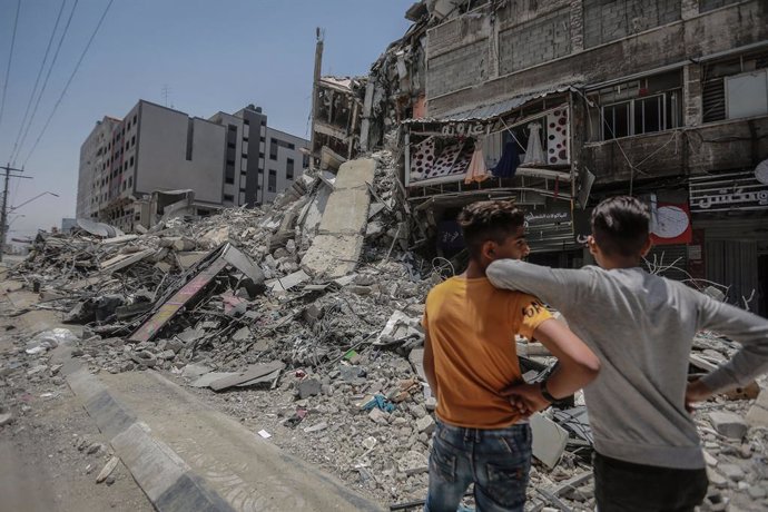 21 May 2021, Palestinian Territories, Gaza City: Palestinians inspect damaged buildings that were hit by Israeli airstrikes during the recent military conflict between Israel and the Palestinian enclave controlled by Hamas. Israel and Hamas have reached