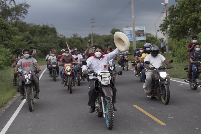 Pedro Castillo a lomos de una motocicleta con un grupo de incondicionales