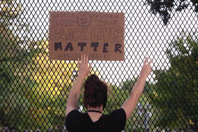 Archivo - Una mujer sostiene un cartel con el lema 'Black Lives Matter' frente a la Casa Blanca en el marco de las protestas por el asesinato de George Floyd a manos de un policía, en mayo de 2020.