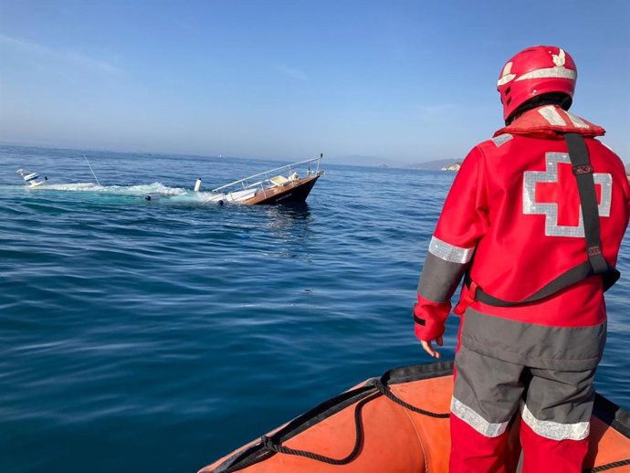 Un voluntario de Cruz Roja observa como se hunde el velero